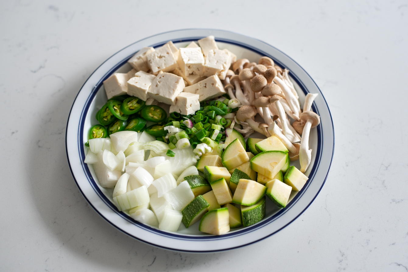 Fresh vegetables, mushrooms, and tofu prepared for doenjang jjigae