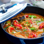 Kimchi Jjigae is made with canned mackerel pike fish in a blue pot.