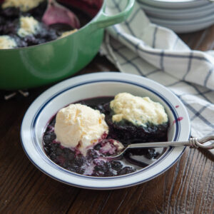 Blueberry dumplings are served with vanilla ice cream.