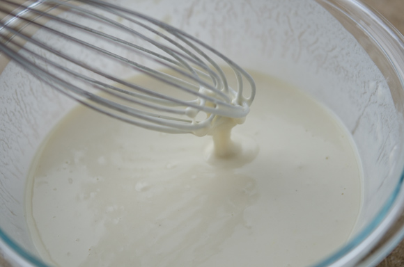 Korean pancake batter is mixed with a whisk in a bowl.