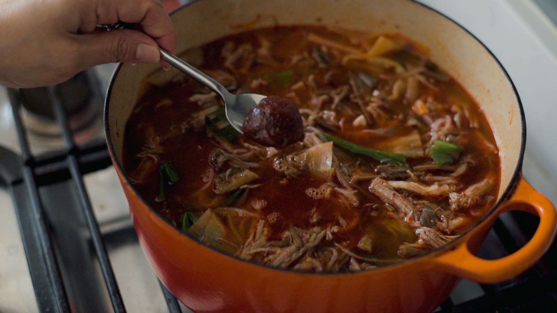 Adding a spoonful of Korean chili paste (gochujang) to flavor yukgaejang
