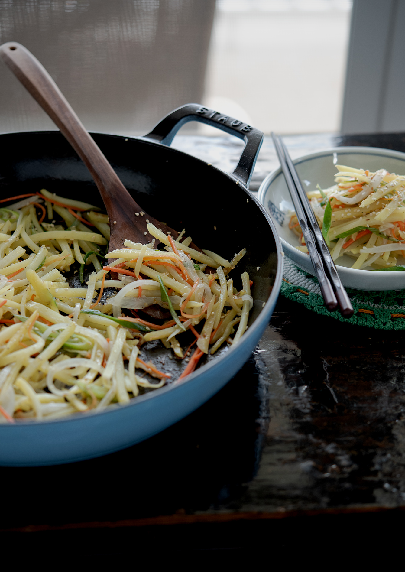 Korean potato side dish (gamja bokkeum) with vegetables in a pan.