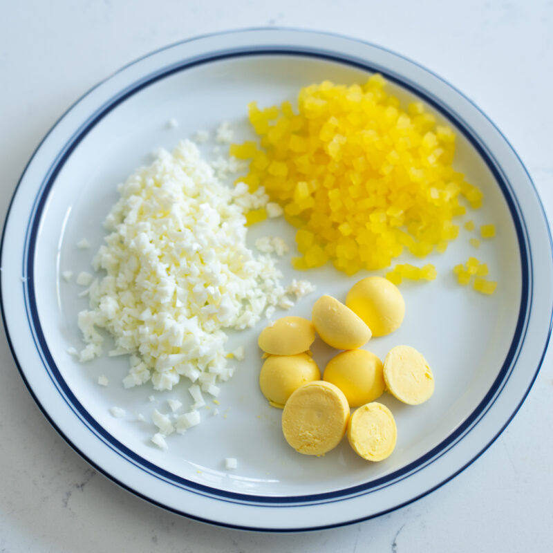finely minced egg white, pickled radish and chunks of egg yolks are on a plate.