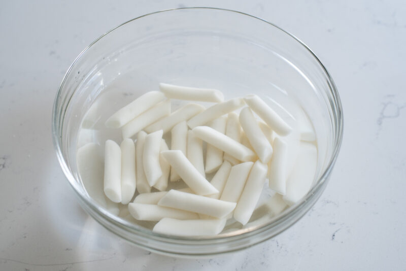 Korean rice cakes (tteok) are soaking in water to prior of making tteokbokki.