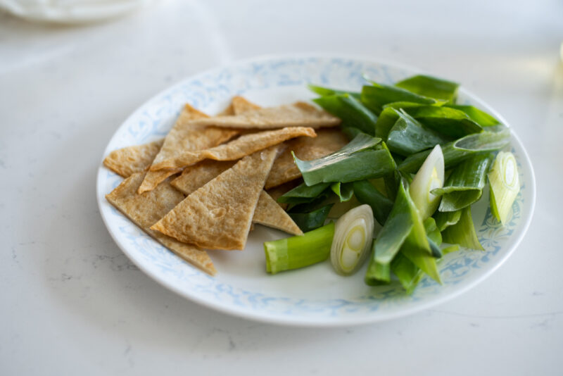 Fish cake sheets and Asian leek are sliced 