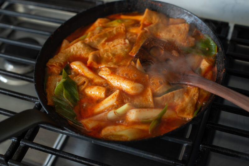 Tteokbokki simmering in sauce with fish cakes and leeks