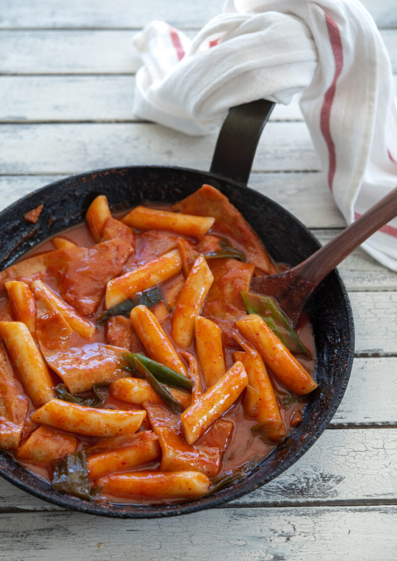 Korean rice cakes and fish cakes (tteokbokki) are made with gochujang in a skillet.