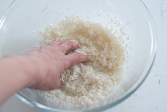A hand is swirling the rice in a.bowl.