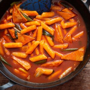 Tteokbokki in spicy gochujang sauce with rice cakes and fish cakes in a pan
