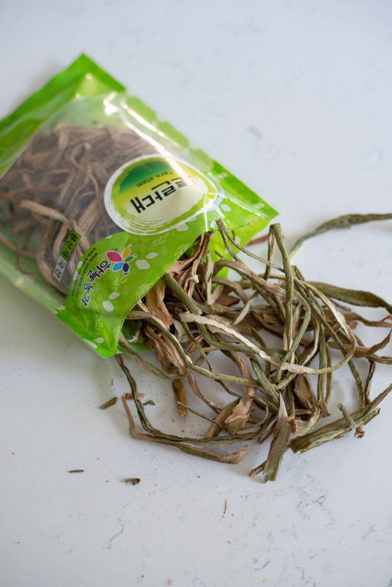 A package of dried taro stem is opened and some of its content is showing on the counter.