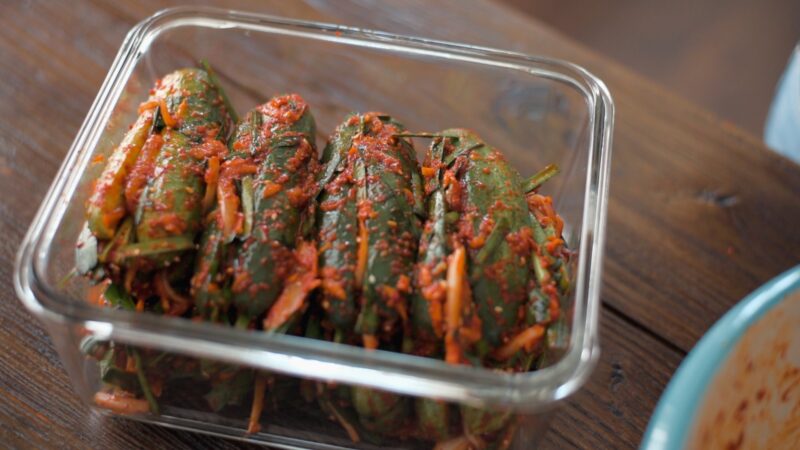 Stuffed cucumber kimchi packed in a glass container.