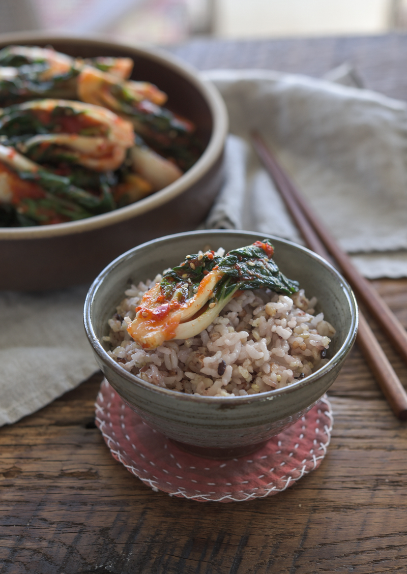 Bok choy kimchi is served with a bowl of rice.