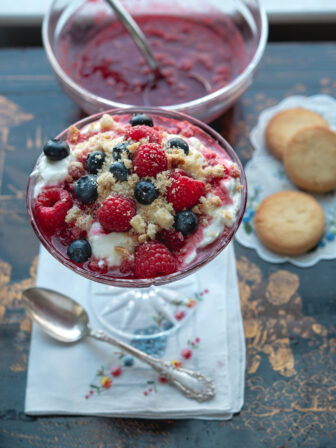 Raspberry fool is a simple raspberries and cream dessert topped with shortbread cooki crumbs