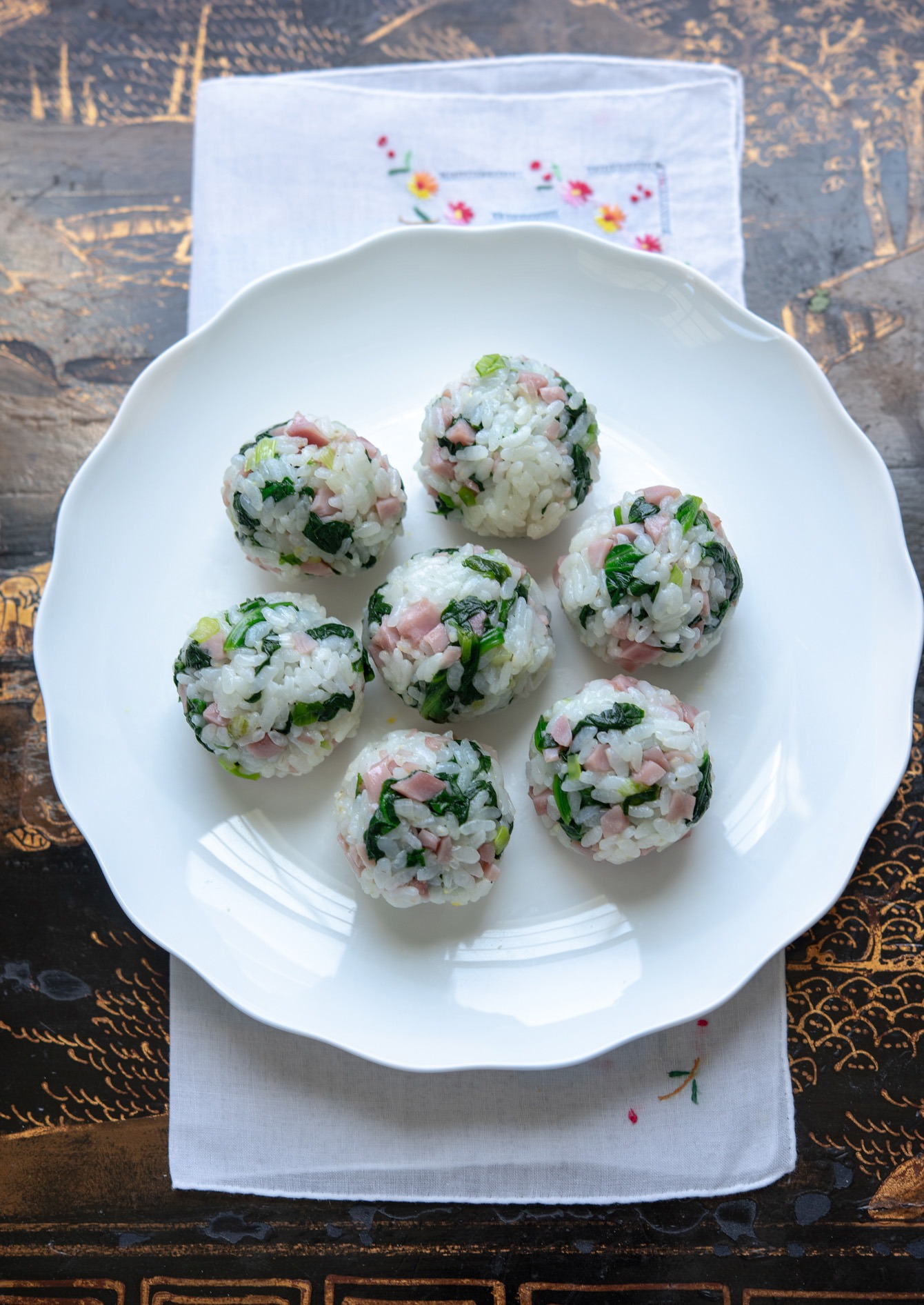 ham and spinach rice balls on a white serving dish.