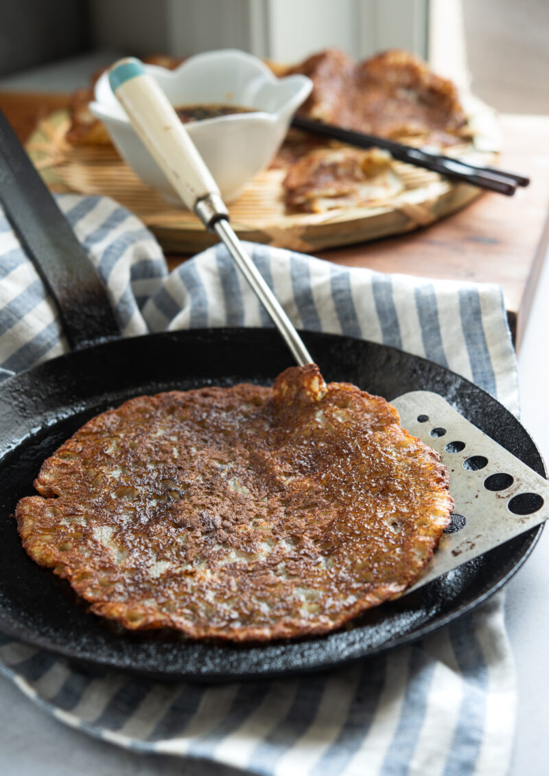 Korean potato pancakes are pan-fried to golden crisp in a skillet.