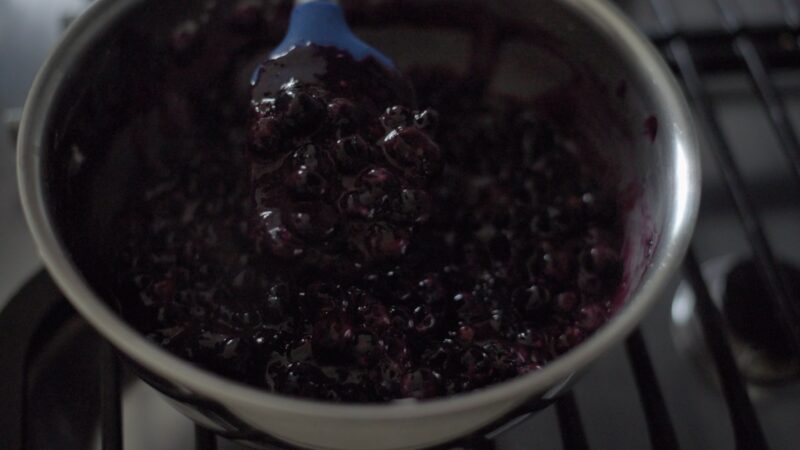 Thickened maple blueberry filling is showing its consistency.