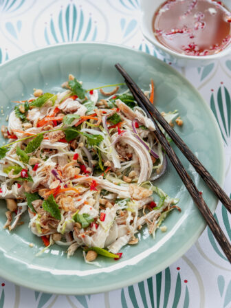 Yummy Vietnamese chicken salad is served on a green plate with fish sauce dressing.