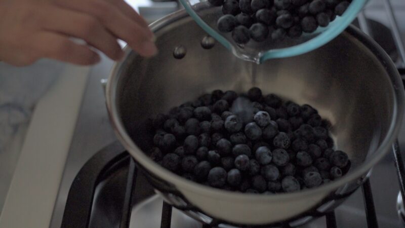 Blueberries are placed in a pot over the stove.