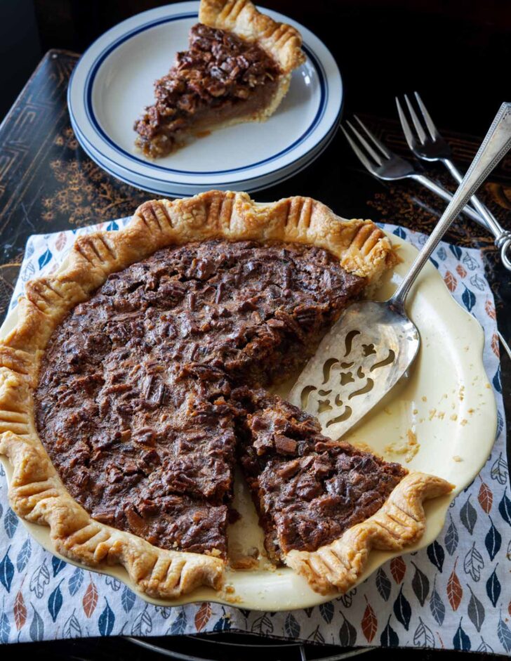 Butterscotch pie in a pie dish with a serving spatula.