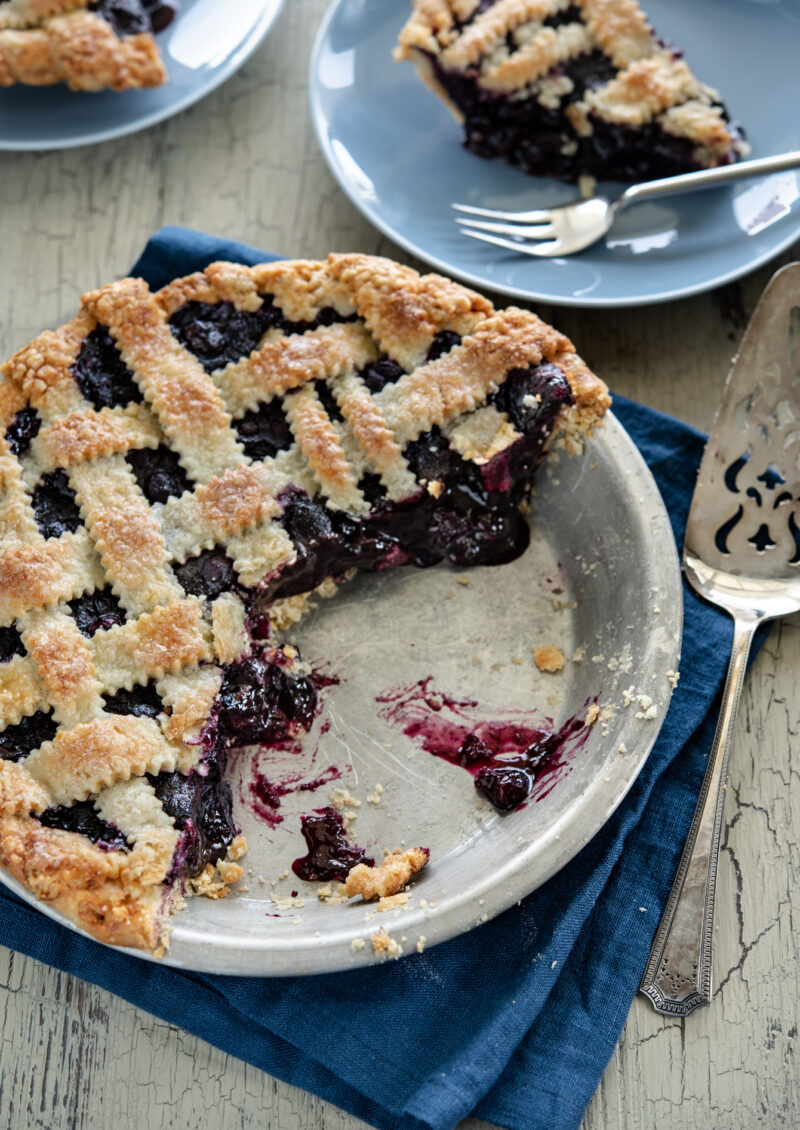 Maple blueberry pie with lattice top crust is cut and served.