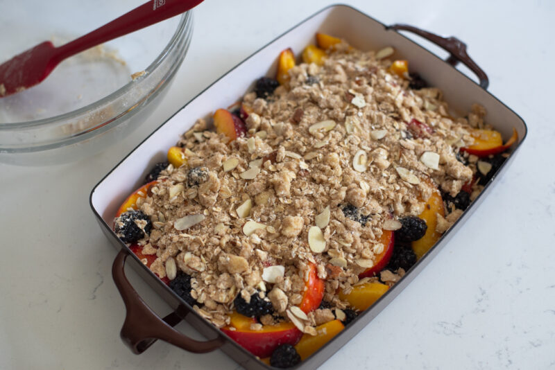 Nectarine blackberry crisp in a baking pan is ready to bake in the oven.