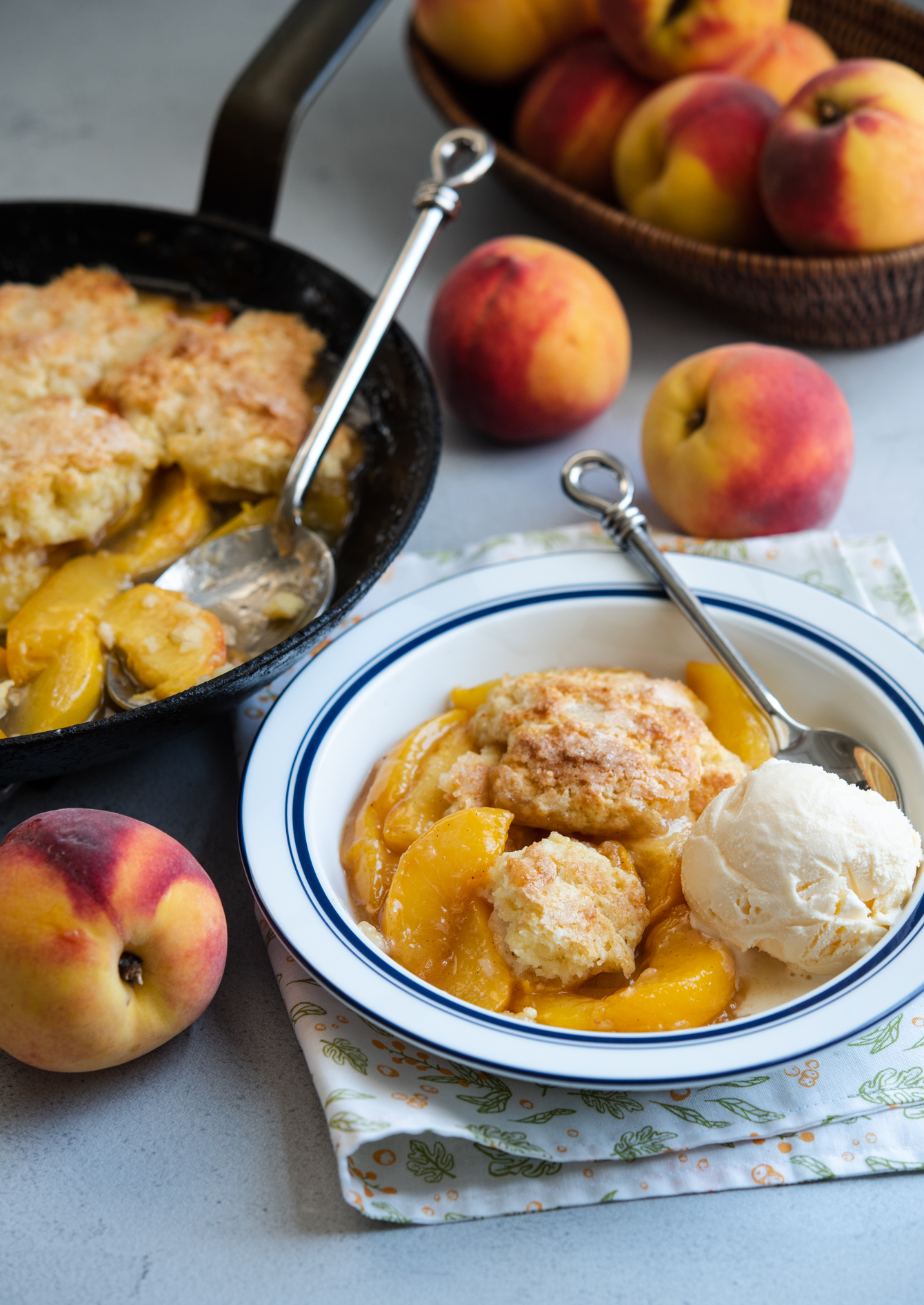 Classic peach cobbler with biscuit topping served with vanilla ice cream