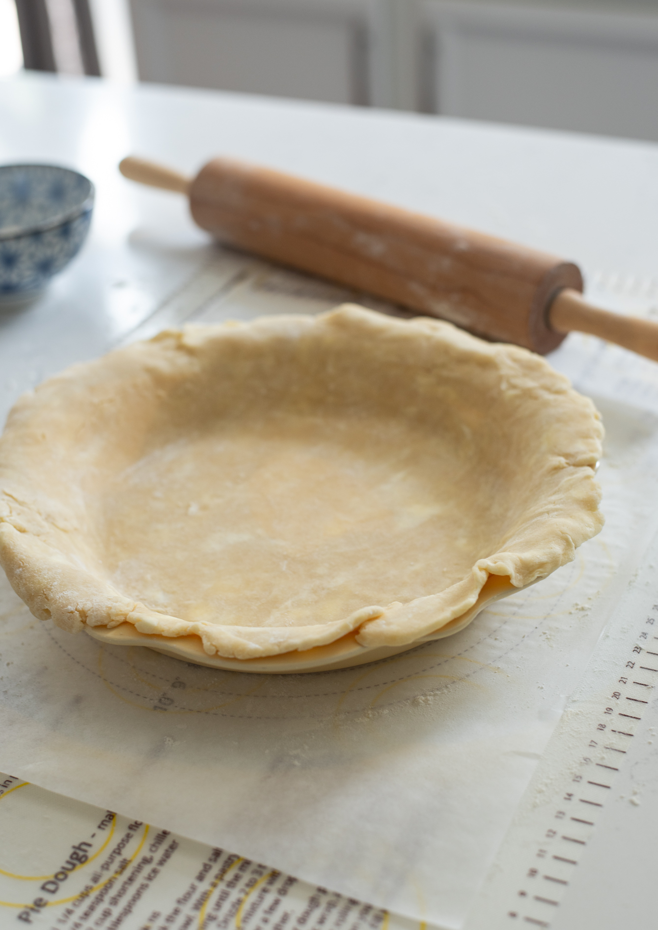 Rolled out pie crust is placed on a pie pan.
