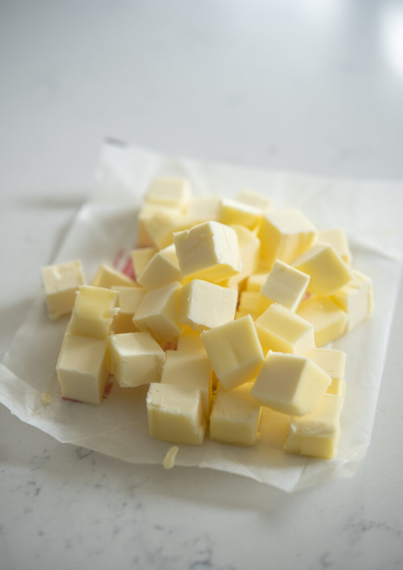 Cold butter is cut into small pieces.