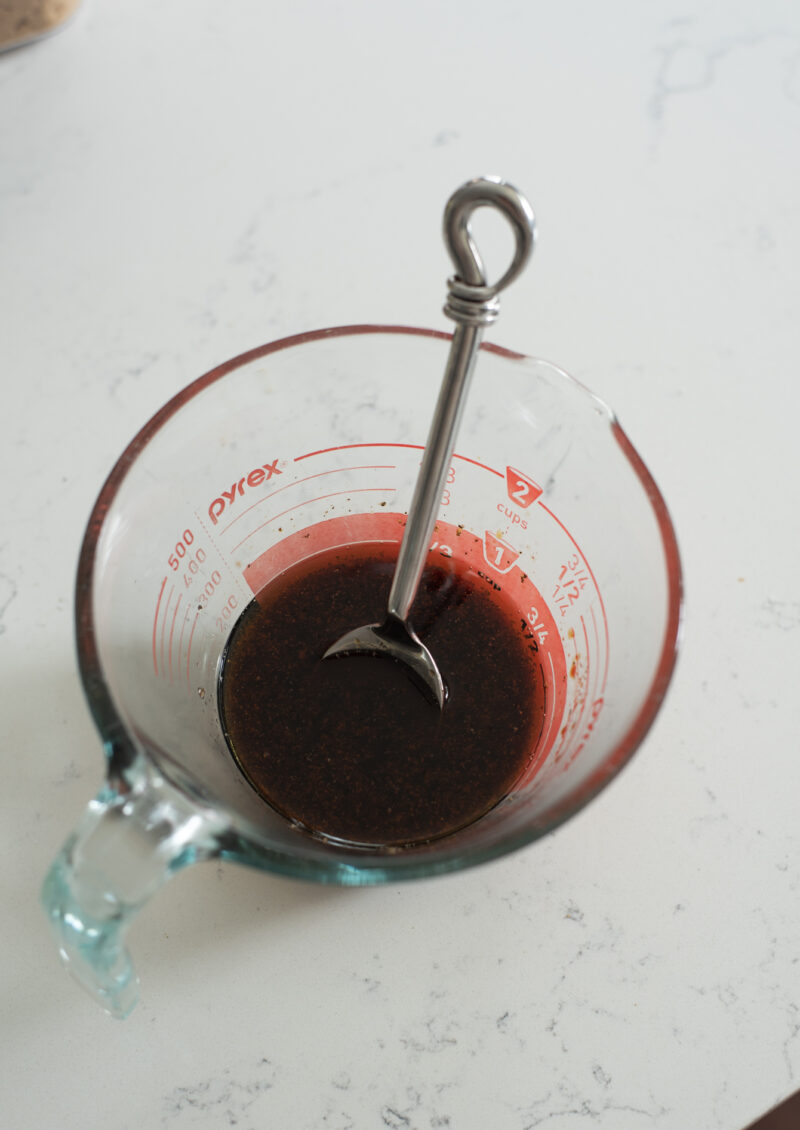 Sauce for sesame soba noodles in a glass cup.