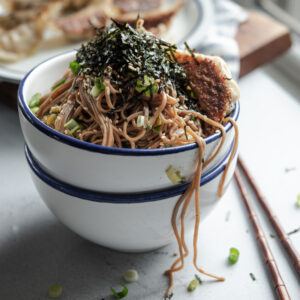 Sesame soba noodles are topped with crumbled seaweed