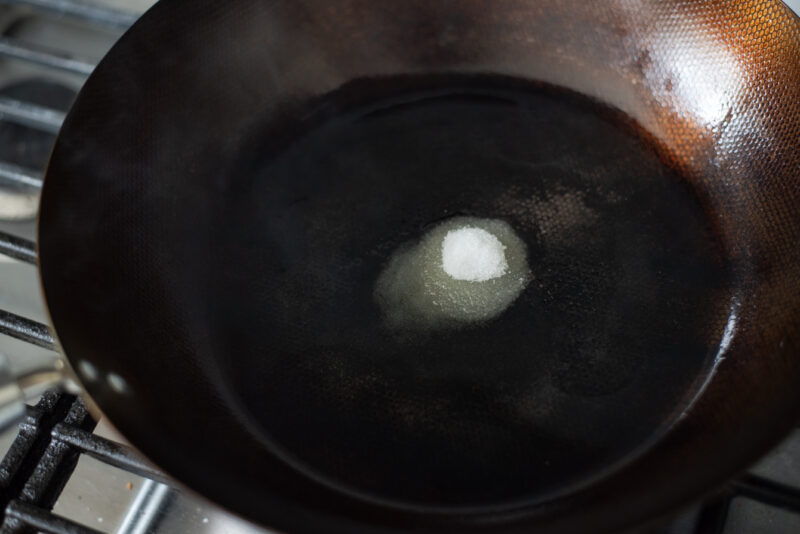 A small anount of sugar is added to hot oil in a skillet.