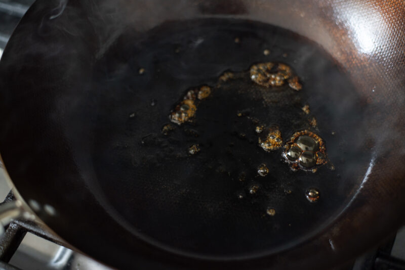 A small amount of sugar is caramelizing in hot oil in a skillet.