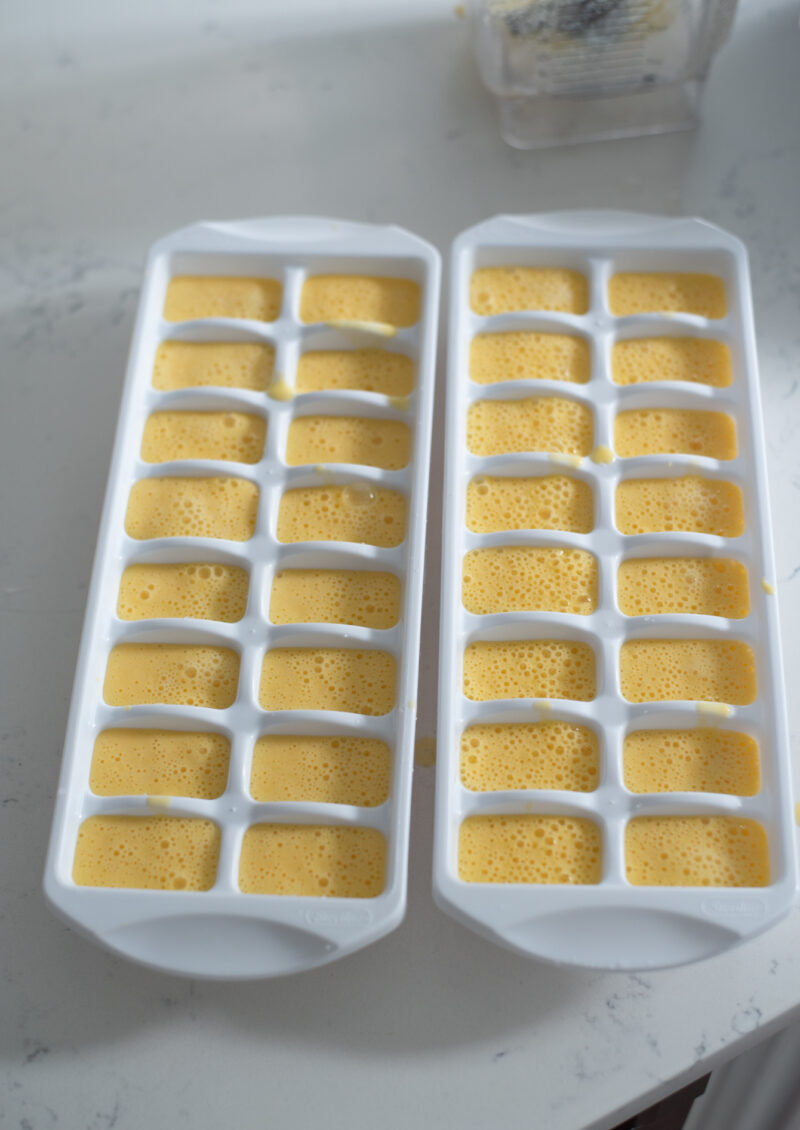 Mango milk puree divided into two ice cube trays.