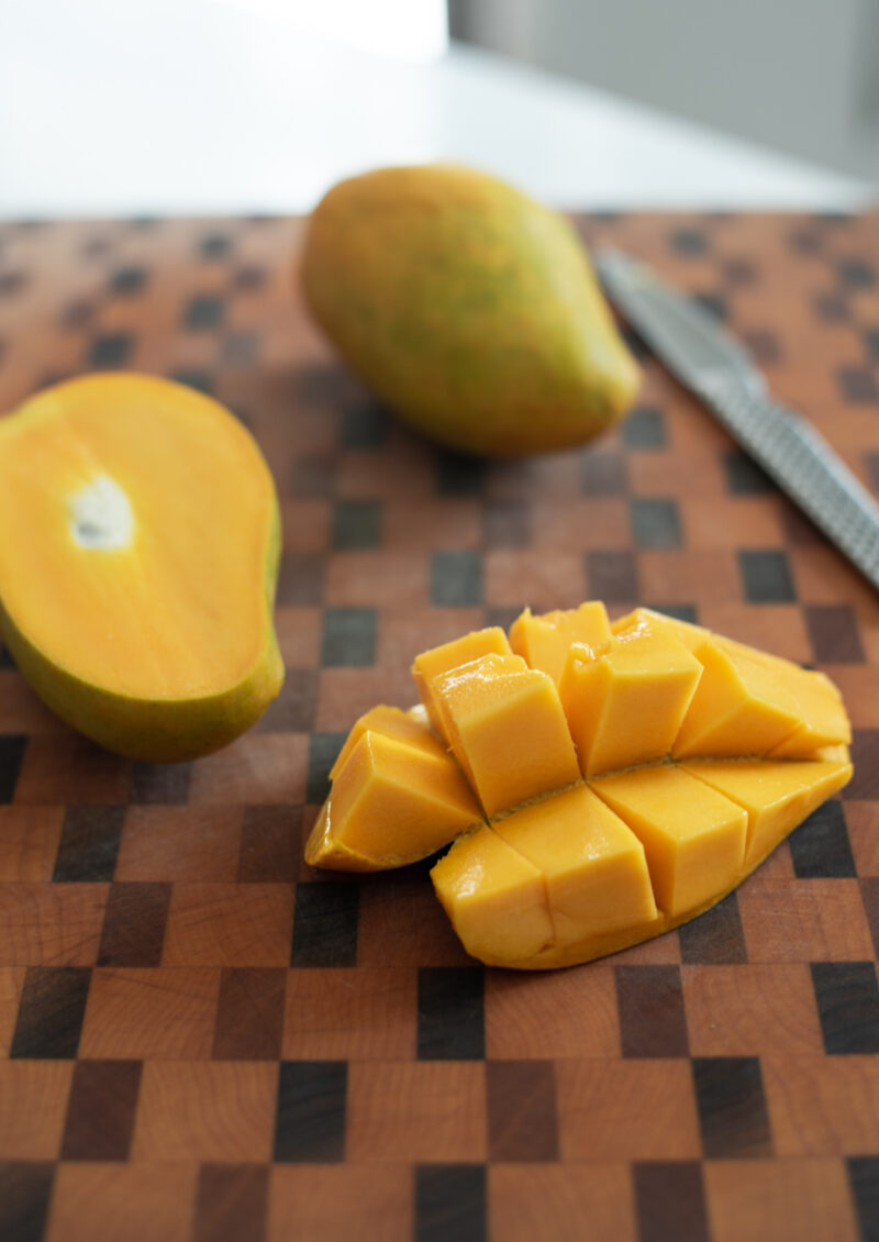 A slice of mango is pushed out to release its fruit.