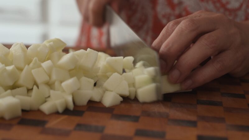 Peeled apple is chopped into small pieces.