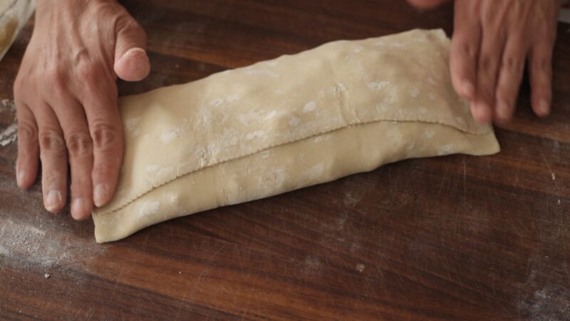 Frozen puff pastry strudel holds the apple filling and rolled.
