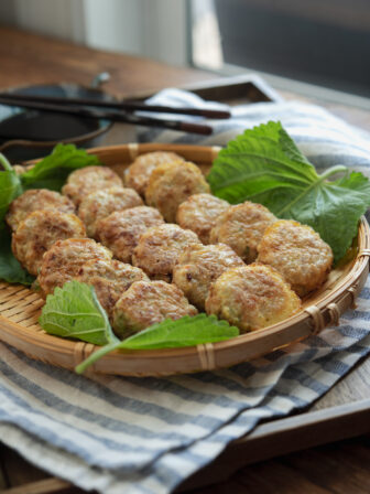 Korean mini patties made with ground pork and tofu are resting on a bamboo plate