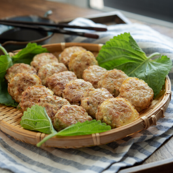 Korean meat tofu patties are served on a bamboo bastket with perilla leaves