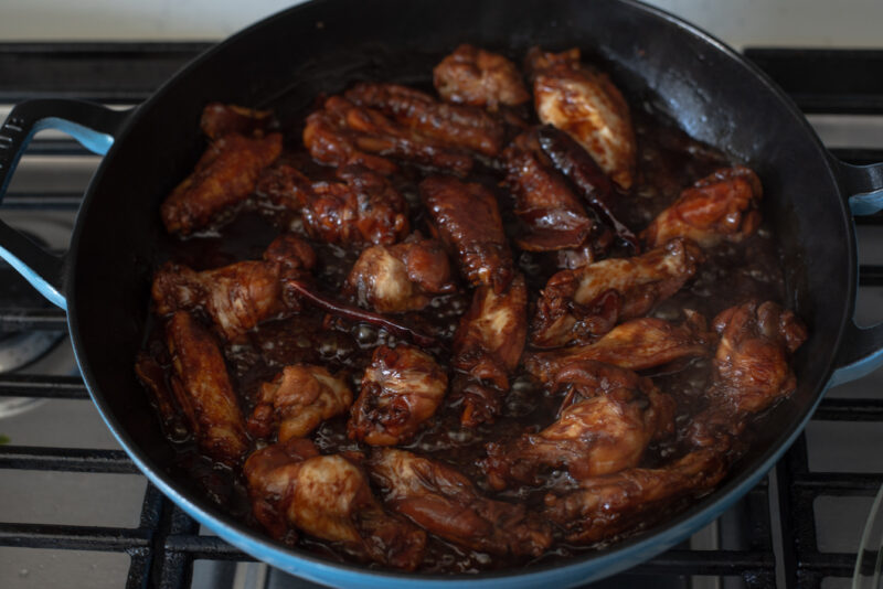 Taiwanese chicken dish is simmering in a dark sauce.