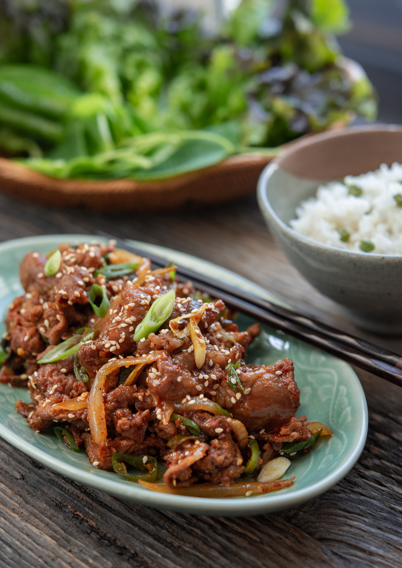 Gochujang sauce Korean pork bulgogi is served with rice and lettuce.