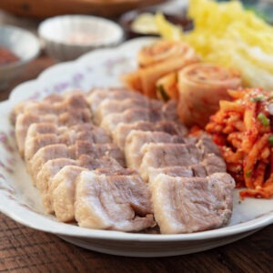 Korean bossam pork belly slices with kimchi and napa cabbage