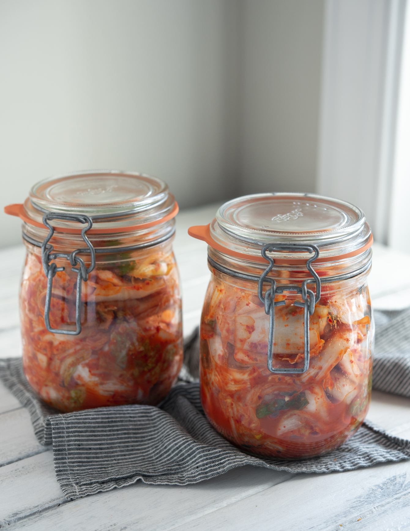 Freshly made cabbage kimchi (Mak-kimchi) is fermenting in glass jars