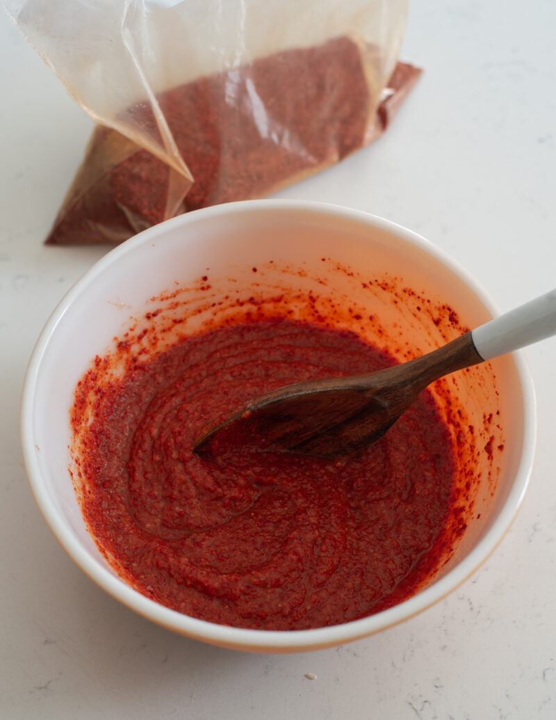 kimchi paste is made in a mixing bowl with Korean chili flakes