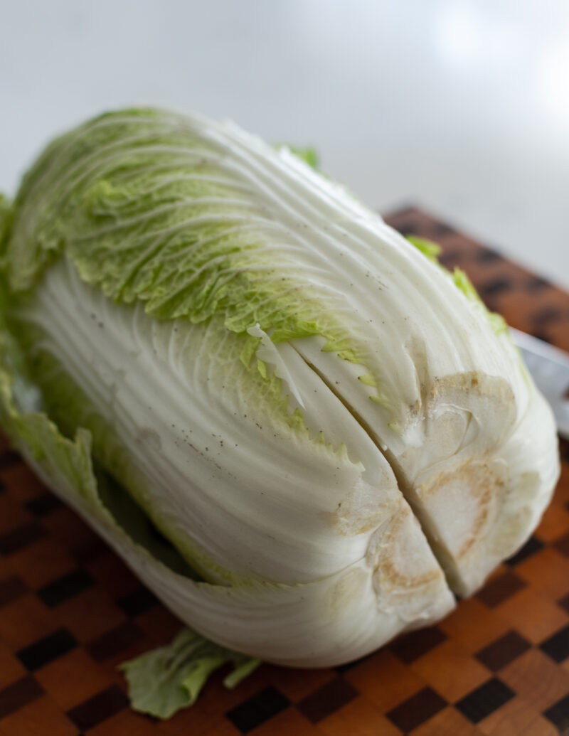 A small slit is given to the white stem part of whole cabbage.