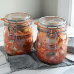 Cabbage kimchi (Mak-kimchi) is fermenting in two glass jars