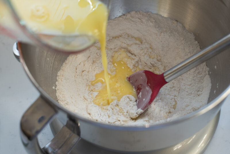 egg and butter mixture is added to the dry ingredients in a mixer bowl.