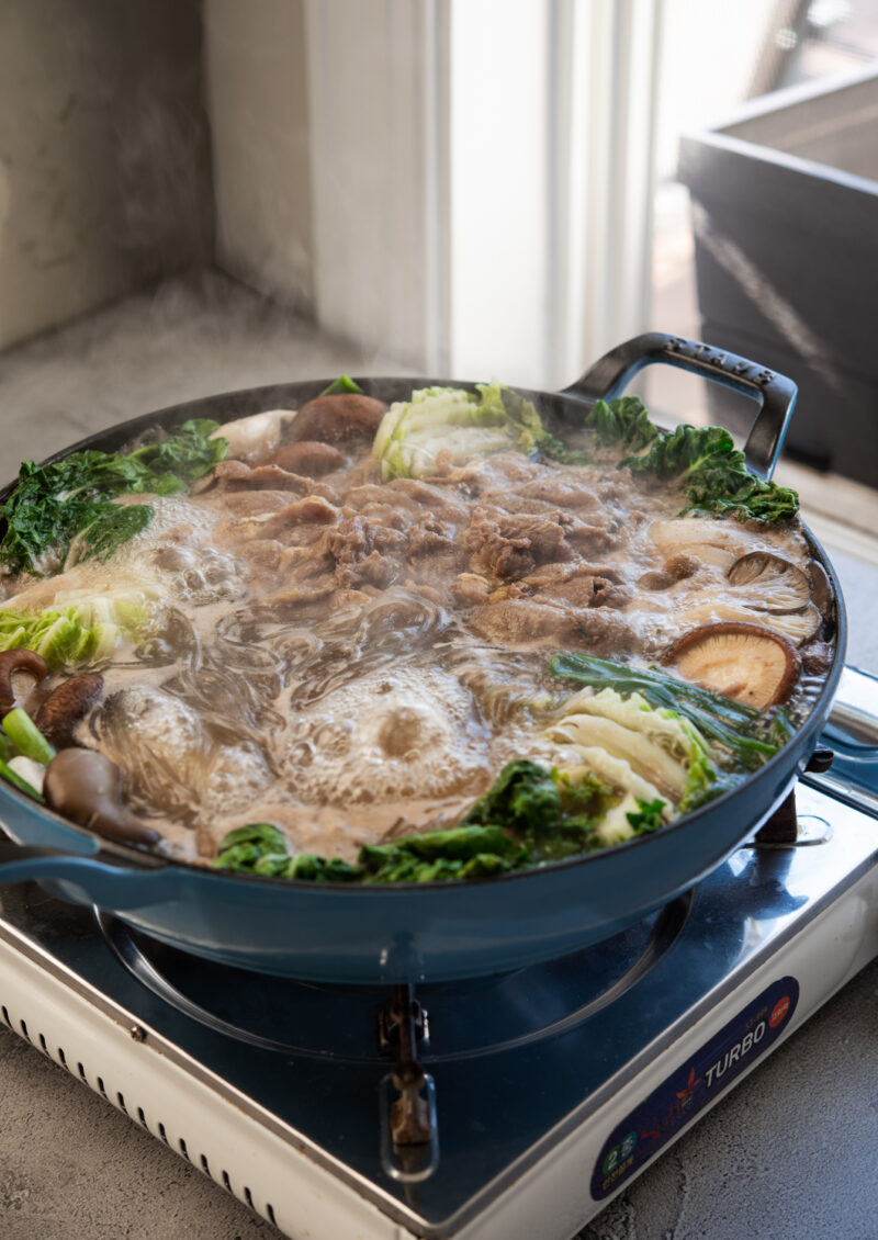 A bulgogi hot pot with mushroom and vegetables is simmering over stove