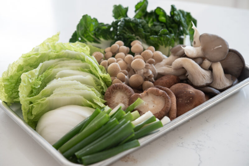 Various vegetables and mushrooms are gathered to make a Korean beef hot pot.
