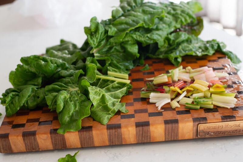 Swiss chard is sliced and the stem parts are collected separately.