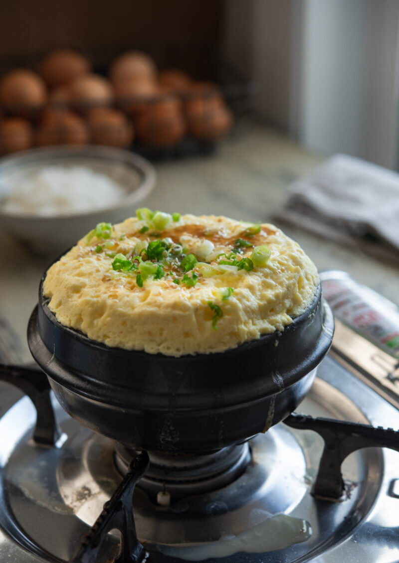 Korean vocano egg side dish is cooked in a stone pot